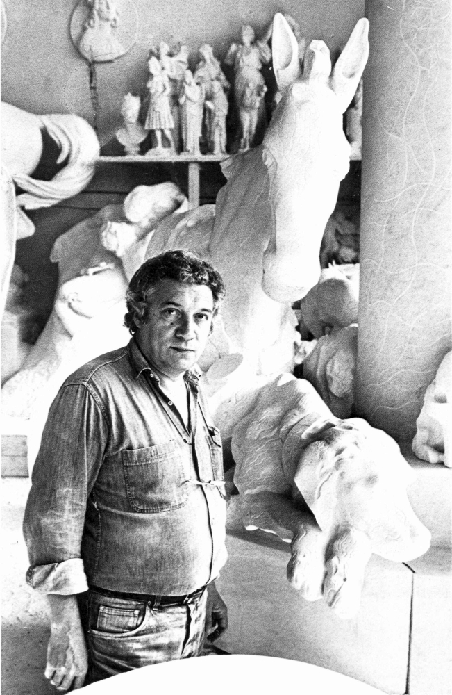 Il Maestro Floriano Bodini nel suo laboratorio con i componenti del Monumento a Virgilio