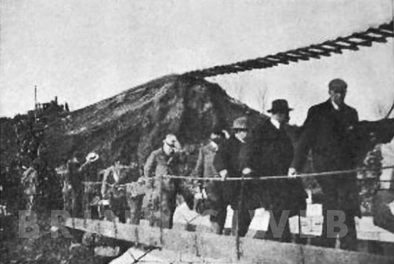 I passeggeri della Valigia costretti al trasbordo dal treno e all'attraversamento del luogo dell'alluvione su una passerella.