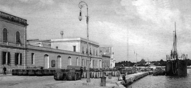 Botti di vino sul lungomare del porto, pronti per l'imbarco sui piroscafi